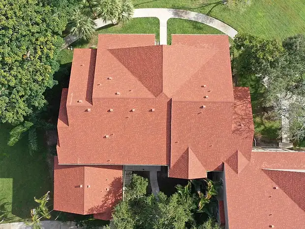 Aerial view of a home with a new terracotta-toned shingle roof