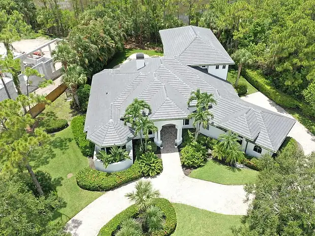 Aerial view of an estate home with a tile roof