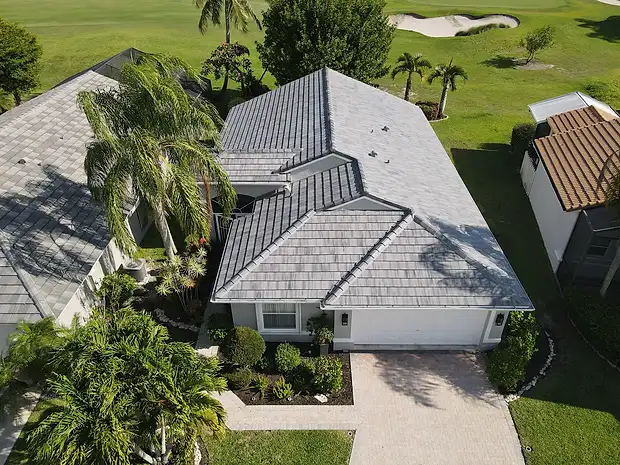 Aerial view of a golf-course home with a grey tile roof