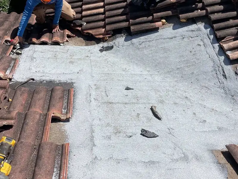 Tile lifted off a roof section with the underlayment exposed underneath